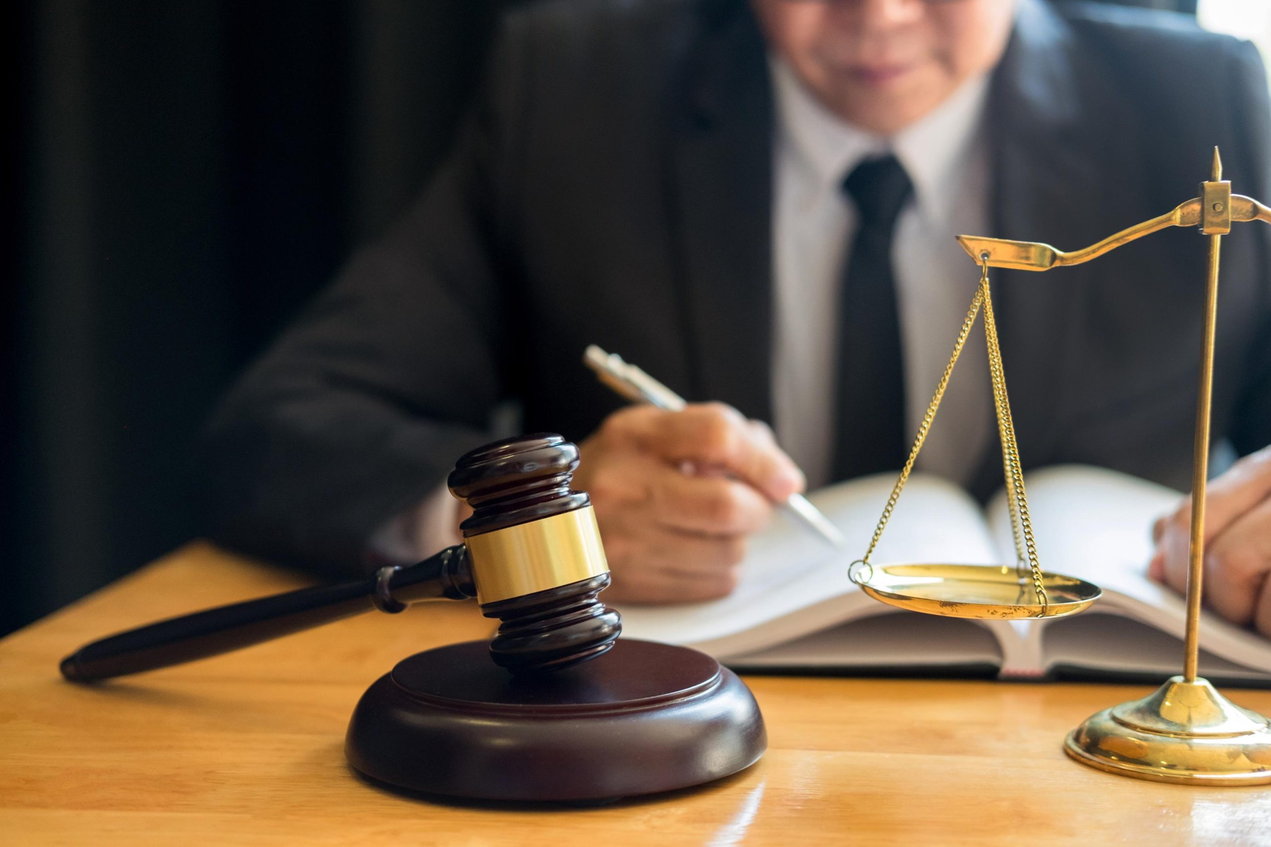 Male lawyer working with contract papers and reading law book