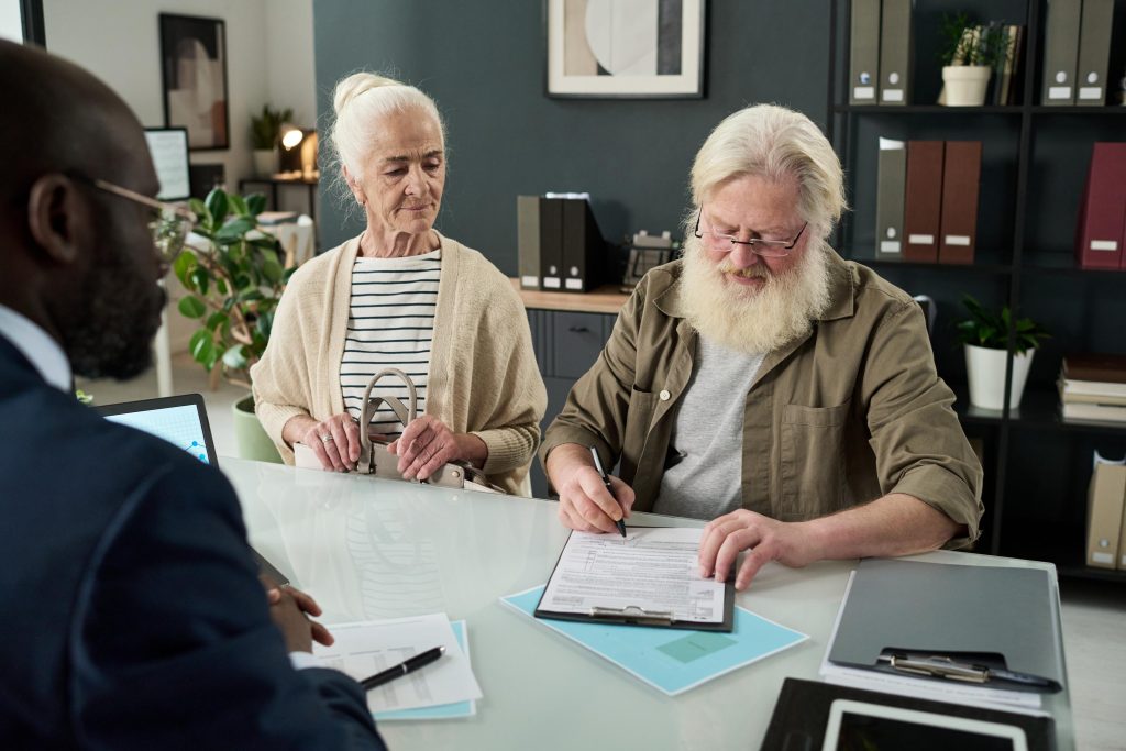 Senior Man Signing Contract In Office