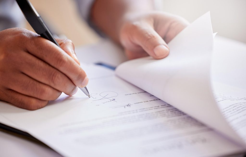 man filling out paperwork while sitting in his house