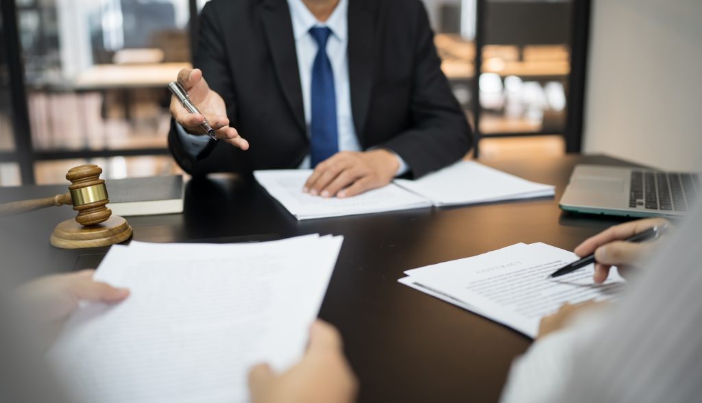 Legal counsel presents to the client a signed contract with gavel and legal law. justice and lawyer concept.