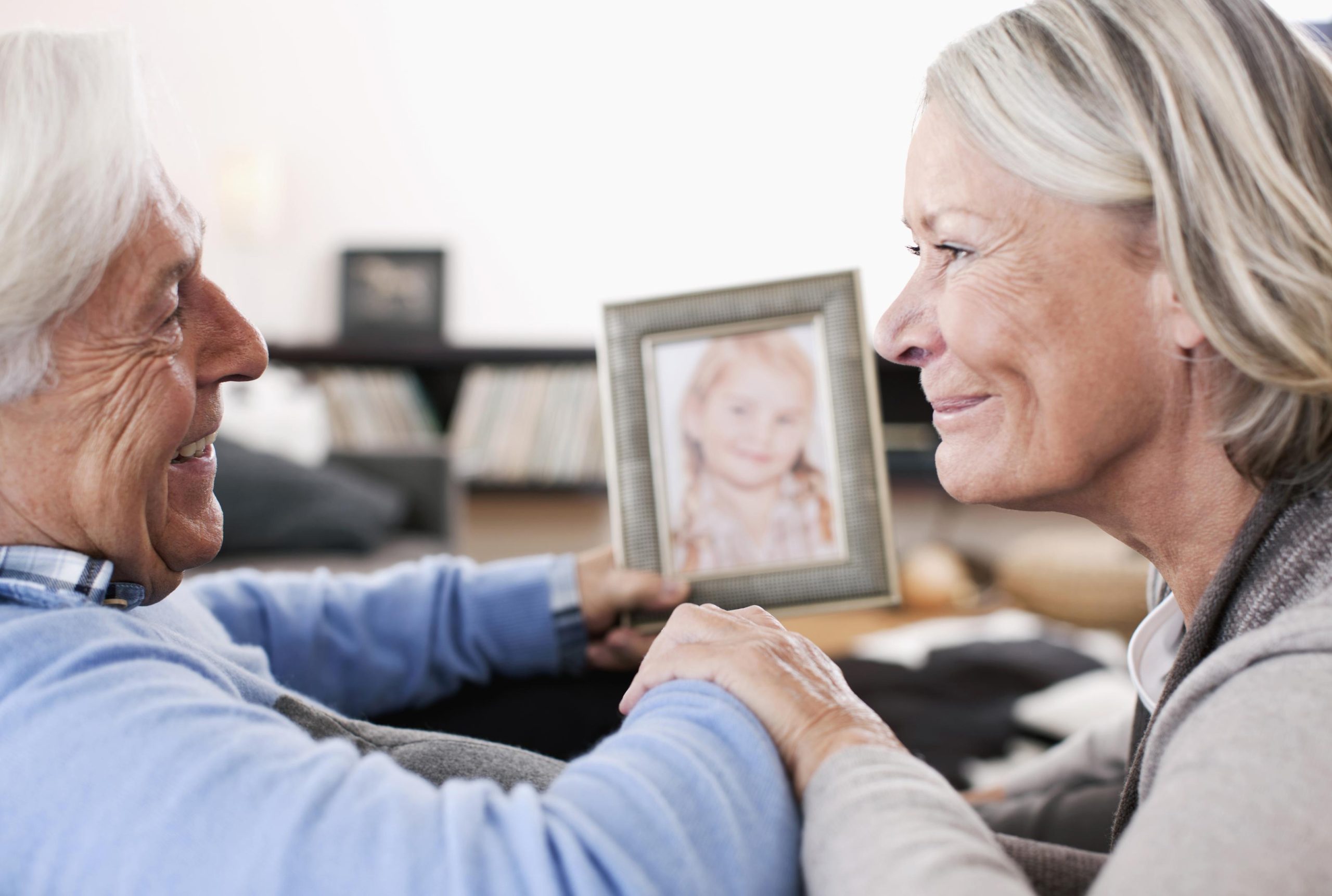 Grandparents holding granddaughter photograph
