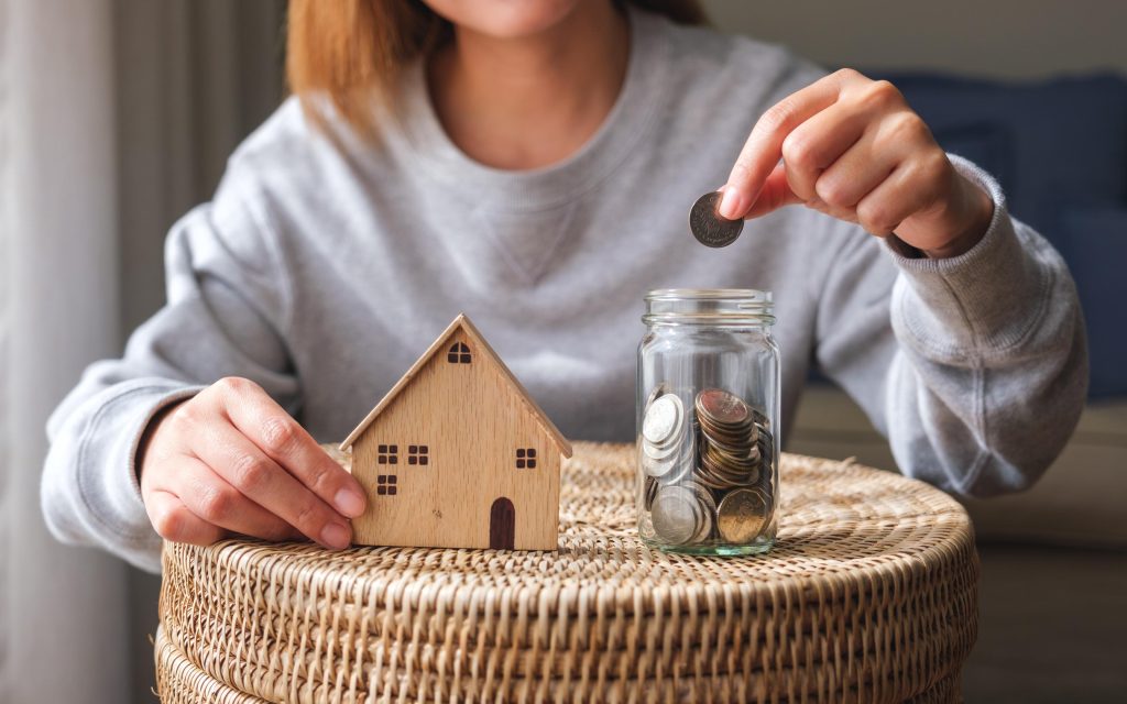 Closeup image of a woman putting coins into a glass jar with woo