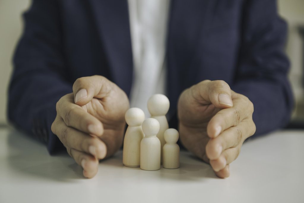 Family financial protection concept with wooden figures and advi