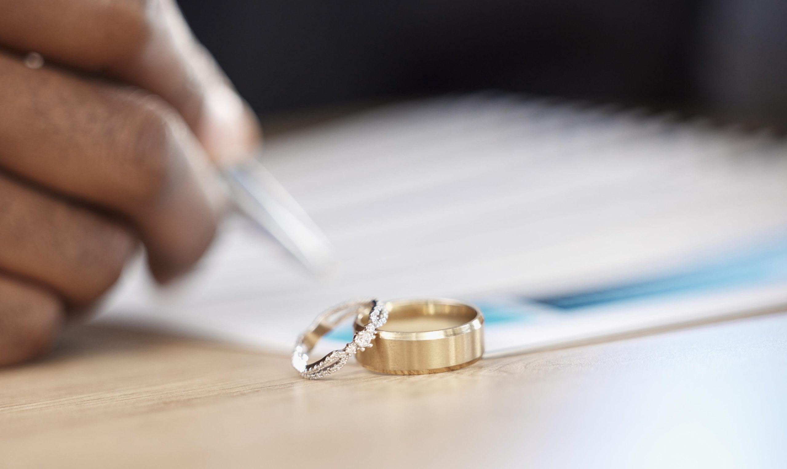 Divorce, rings and signature on paperwork for a lawyer, register wedding or writing on a contract. .