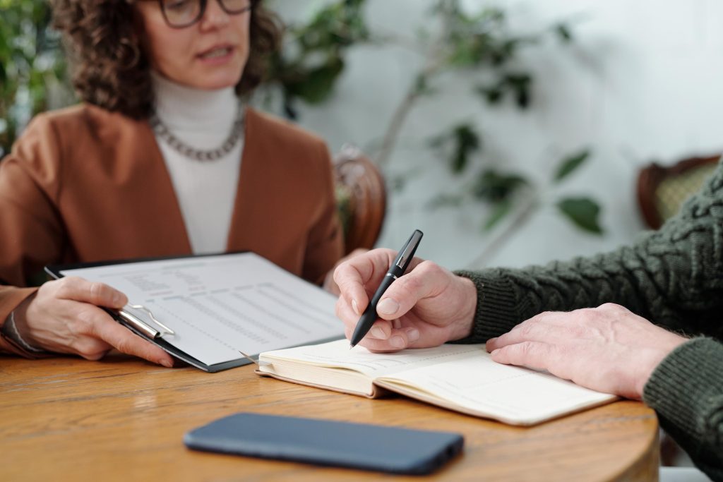 Discussion Between Colleagues About Document at Wooden Table